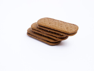 Stack of chocolate cream sandwich biscuits on a white background, sweet and crunchy with visible sugar crystals