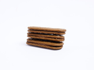 Stack of chocolate cream sandwich biscuits on a white background, sweet and crunchy with visible sugar crystals