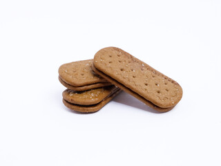 Stack of chocolate cream sandwich biscuits on a white background, sweet and crunchy with visible sugar crystals