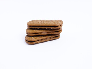 Stack of chocolate cream sandwich biscuits on a white background, sweet and crunchy with visible sugar crystals