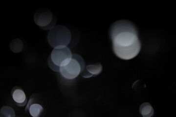 white and fire silver bokeh on a black background, bokeh abstract background, modern technological abstract background. white Christmas background, Xmas backdrop 
