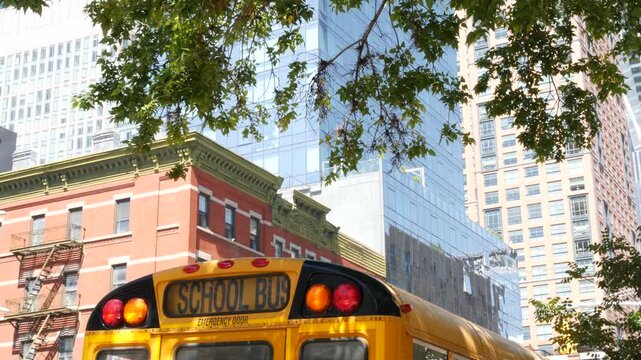Yellow School Bus on New York Manhattan street, schoolbus truck on city road. Children education and transportation, USA. American school shuttle, 10 avenue Chelsea red brick house, United States.