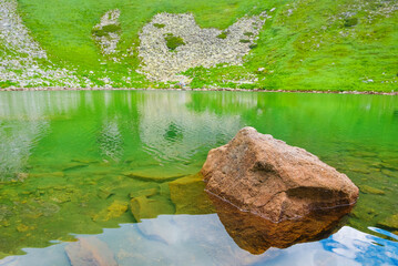 Fototapeta premium small calm lake on green mountain valley