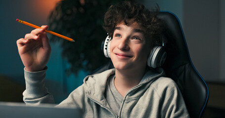 Obraz premium A student holds a pencil and quietly studies his screen. He thinks about his project and imagines how to build something new based on what he has already done.