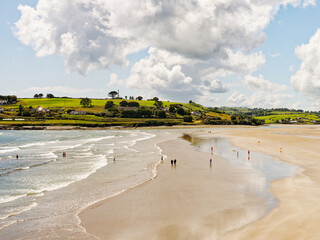 West Cork, June 25, 2023. A stunning view of a beach, with people enjoying a summer's day. The contrast between the sand, sea and green hills creates a peaceful, beautiful scene.