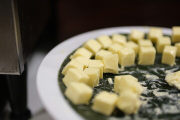 Butter slices are placed on a plate, Cut butter into cubes for baking cake, Whole Pieces of Fresh...