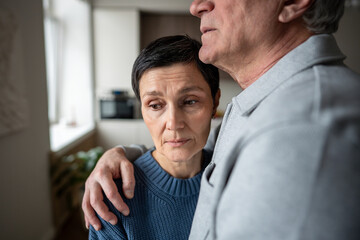 Senior woman in husband embrace comforting thoughtful sad mood. Marital support in hardships, empathy of senior family, love elderly care, health issues, soothing consoling partner, aging bonding
