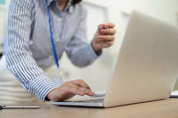 Remote Work Engagement. Businesswoman holding pen, focused on laptop.