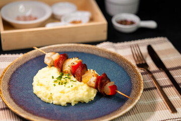 Typical czech cuisine chicken skewer with red pepper, onion, sausage and mashed potatoes