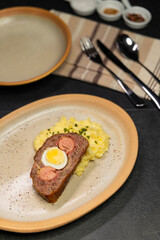 Typical Czech cuisine minced roast pork and beef with egg, sausage and mashed potatoes