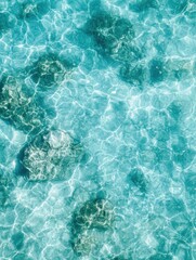 Crystal clear turquoise water with sunlit ripples over submerged rocks. Aerial top view blue water background with copy space