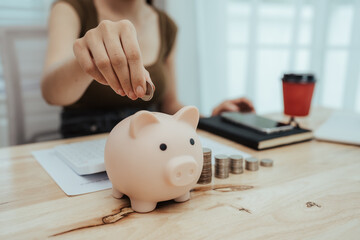 Close-up of woman putting coins into piggy bank, symbol of savings, financial growth, investment, future security, budgeting and basic money management education.