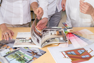 Unrecognizable team of architects and designers working on a home renovation pointing