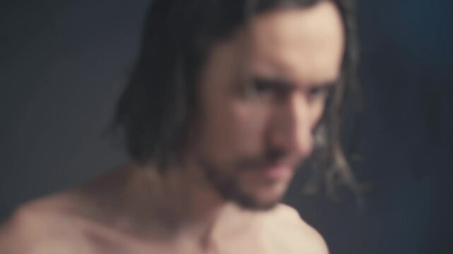 Introspective Male Figure with Long Hair in Soft Focus: Contemplation and Emotional Depth Captured in Moody Atmosphere