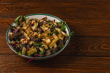 Fresh salad with meat and vegetables served on wooden table