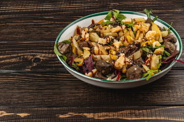 Savory salad with grilled vegetables and meat on wooden table
