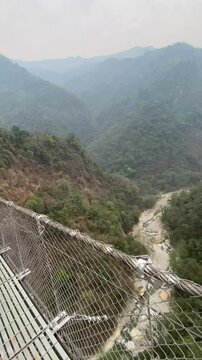 Long suspension bridge at Jhinu Danda during hiking to Annapurna Base Camp (ABC) with modi khola river under it.