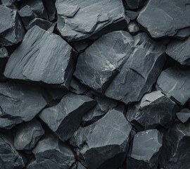 Close-up of a dense collection of dark gray, irregularly shaped, rough-textured stones