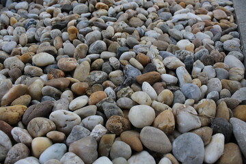 Smooth round pebbles texture background. Pebble sea beach close-up, dark wet pebble and gray dry pebble. natural gravel, texture from gravel. Gravel texture. Pebble stone background. Granite gravel
