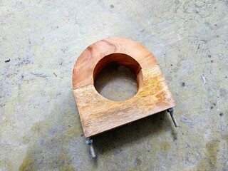 Wooden pipe clamps with bolt fasteners, for holding cylindrical pipes during welding or assembly. Ideal for workshops and mechanical fabrication tasks