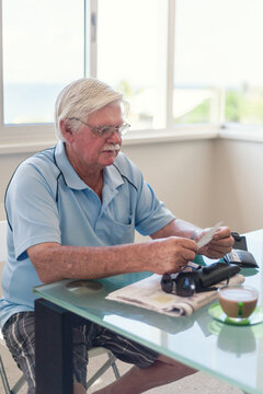 senior man checking his receipts, or is the lotto?