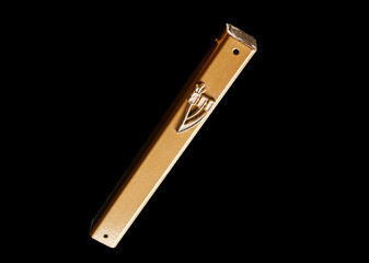 One mezuzah, close-up, isolated on black.