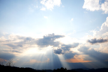 Dramatic sky with sun ray shining over the mountain