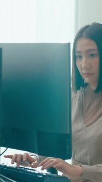 Vertical Screen : Young Asia female freelance typing write prompt AI bot IT app program nomad, video game, terminal with coding language, user interface, designer, big data center on desktop computer.