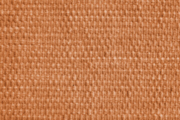 Texture of orange natural fabric with large weaving. Surface, structure of upholstery or carpet material, cloth background close up.