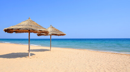 Straw Parasols on Quiet Tropical Beach with Azure Blue Sea View