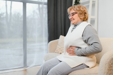 Elderly senior woman stomach ache illness, food poisoning in patient with bacterial infection....