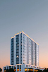 Modern high-rise residential building with minimalist architecture and clear blue sky
