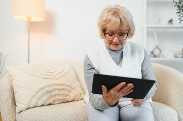 Old happy woman having a video call with her family on a tablet