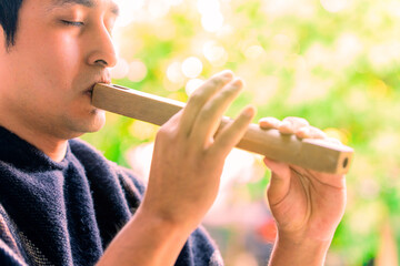  Indigenous man playing Andean instrument at an outdoor festival