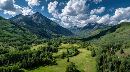 Lush green valley nestled between towering mountains under a vibrant blue sky dotted with fluffy white clouds; a tranquil scene of nature's beauty