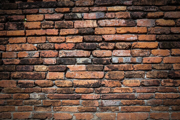 Old grunge brick wall background, Close-up of an old red brick wall with a weathered and textured surface, showing variations in color, age, and mortar lines.