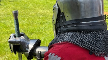 Cavaliere con la sua spada con l'armatura in un prato