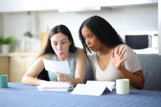 Surprised interracial women checking bank statement