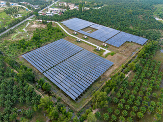 Aerial view of a solar farm surrounded by lush greenery.