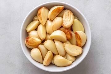 Roasted garlic cloves in a white bowl, healthy food and flavor enhancer
