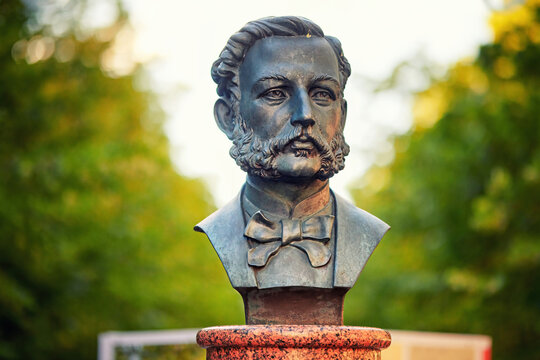 Minsk, Belarus. Jun 21, 2024. Realistic bronze bust of Red Cross founder Henry Dunant in Minsk, set against leafy green backdrop, detailed craftsmanship and cultural significance