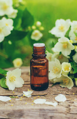 Jasmine essential oil and flowers. Selective focus.