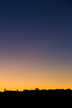 Graduated colour on twilight night sky, with silhouette skyline