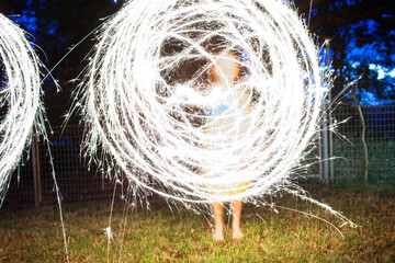 Girl creating a circle shape with a sparkler at night