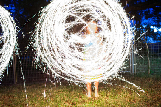 Girl creating a circle shape with a sparkler at night