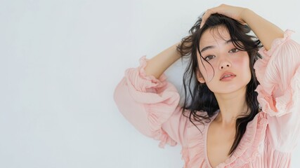 Fototapeta premium Stylish young woman posing with hands in hair. Fashion and confidence concept 