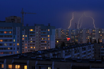 Lightning strike in the city. Storm outside. Thunderstorm with lightning in the city. Moment lightning