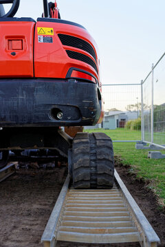 Small excavator red mini digger at a construction site