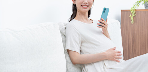 携帯を持つ妊婦