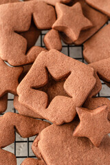 Shortbread chocolate cookies with curred star form on baking tray, close up
